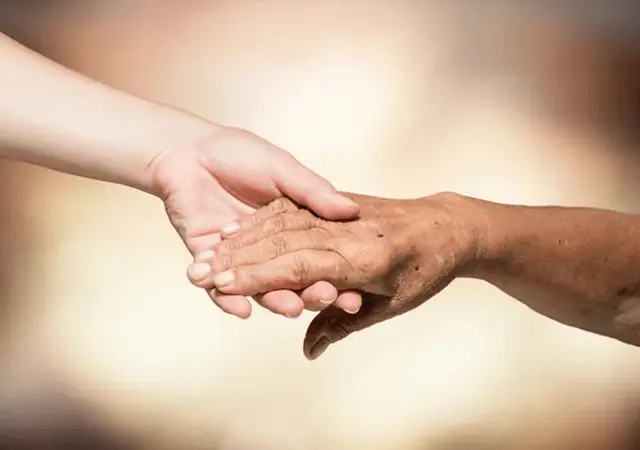 Two people holding hands in a close up picture.